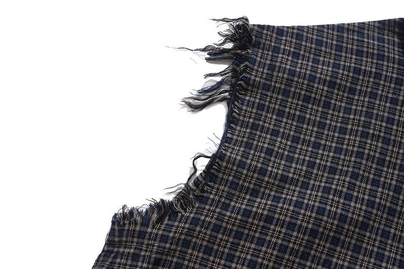 Close-up of raw-cut armhole edge on dark plaid sleeveless shirt