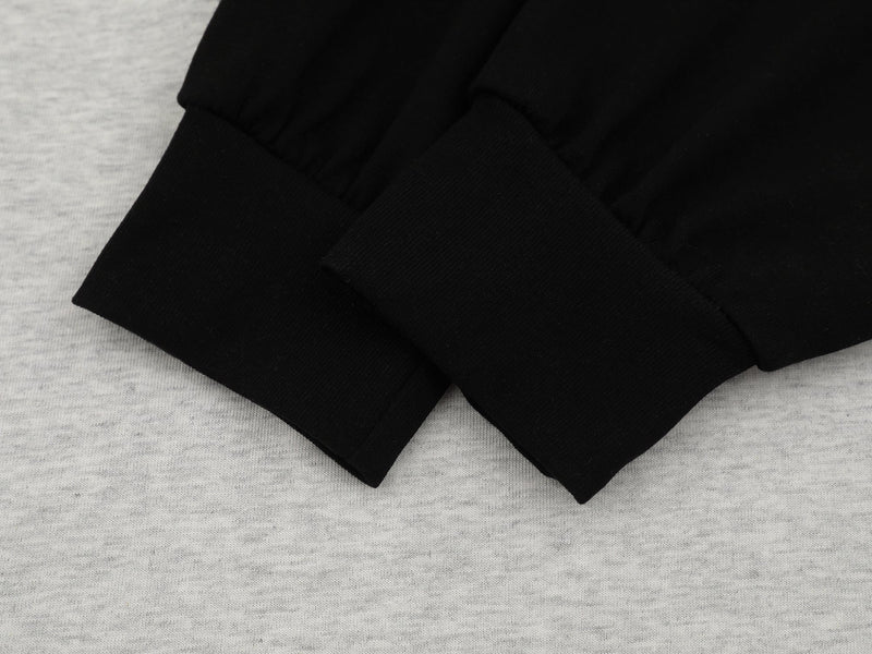 Close-up of black sleeve cuffs layered over heather gray fabric