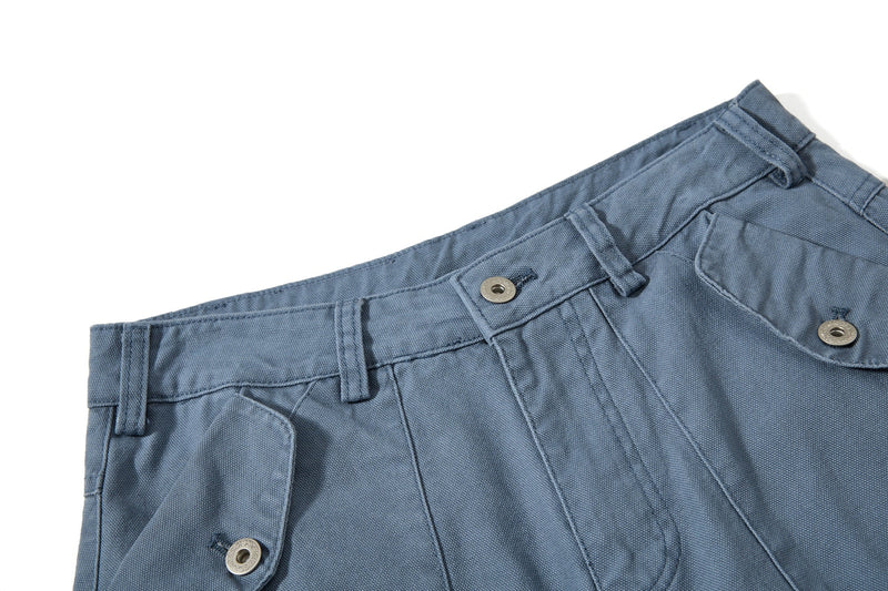 Close-up of blue cargo pants waistband with belt loops and snap button