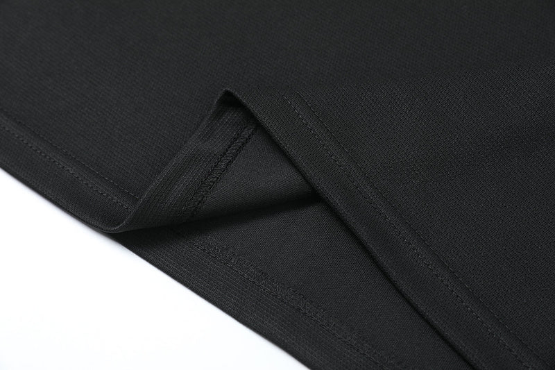 Close-up of a matte black oversized tech T-shirt hem with textured fabric and clean stitched detailing