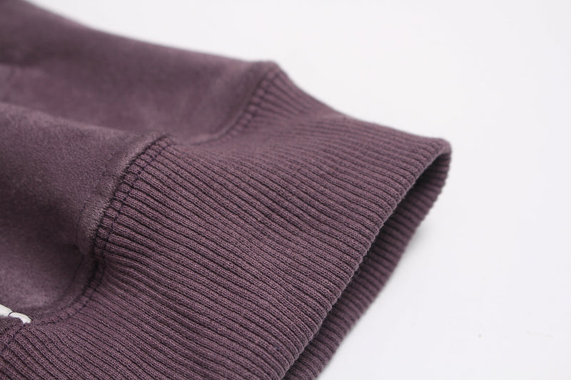Close-up of ribbed cuff and sleeve hem on purple suede hoodie