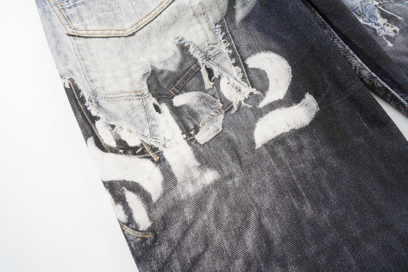 Close-up of a black-and-white graphic print on distressed patchwork denim