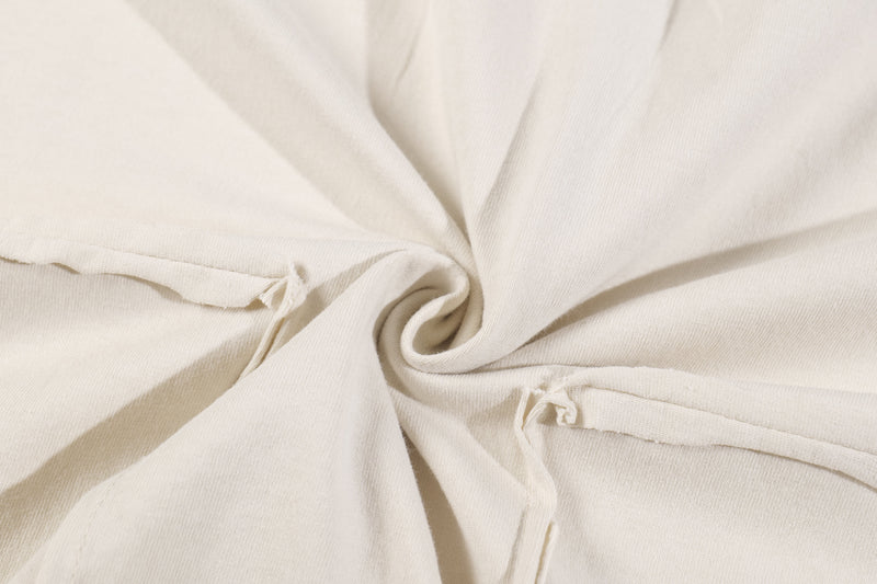 Close-up of twisted cream cotton fabric with patchwork seam detail