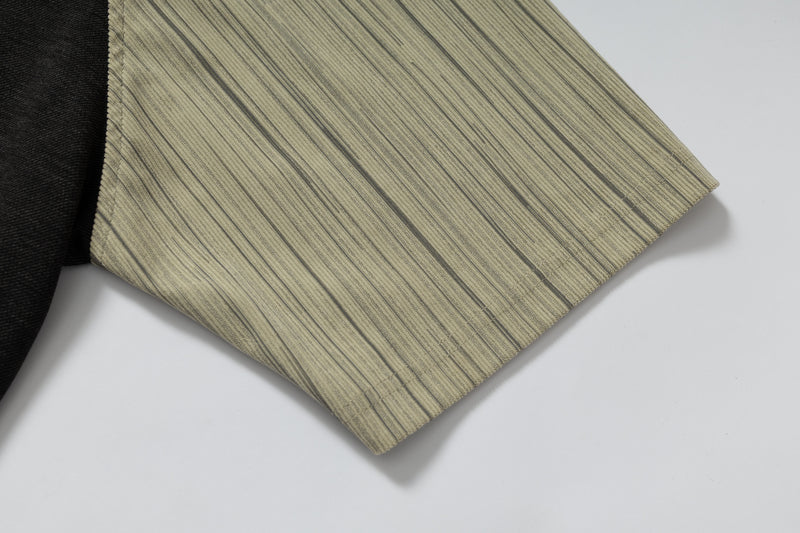 Close-up of a beige striped raglan T-shirt sleeve with black shoulder panel on a clean white background