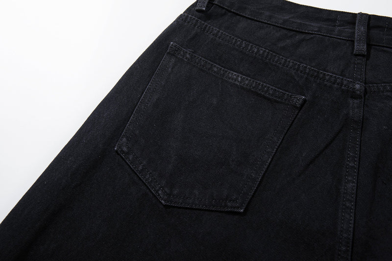 Close-up of the back pocket on black denim jeans with clean stitching
