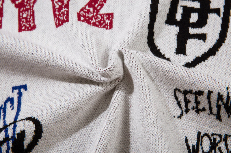Close-up of red, black, and blue embroidery on white knit sweater back