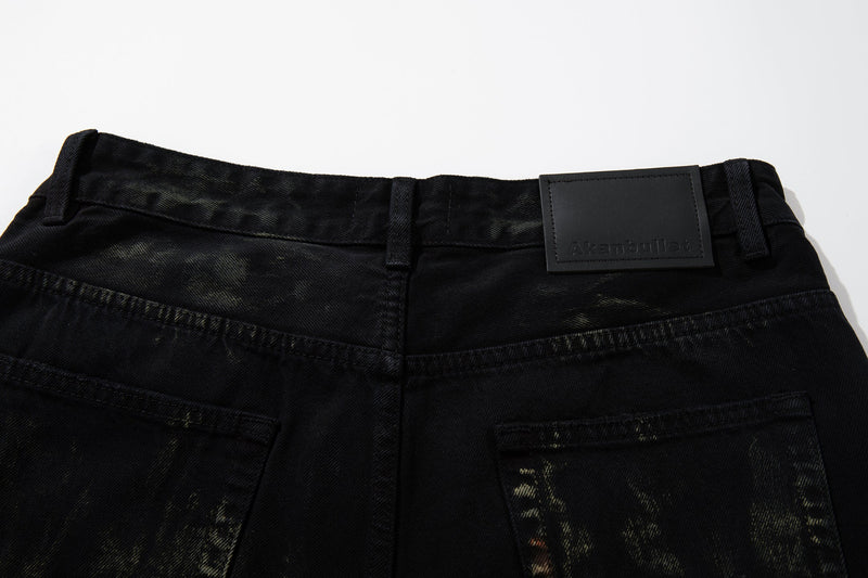 Close-up of waistband on black denim jeans with belt loops and branded patch