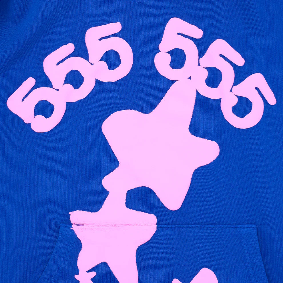 Close-up of the Sp5der “555 Stars” Hoodie – Royal Blue / Pink 440GSM Heavyweight Oversized Streetwear Pullover, showcasing light pink 555 numbers above an abstract star and a partial pocket, reflecting bold Y2K streetwear vibes.