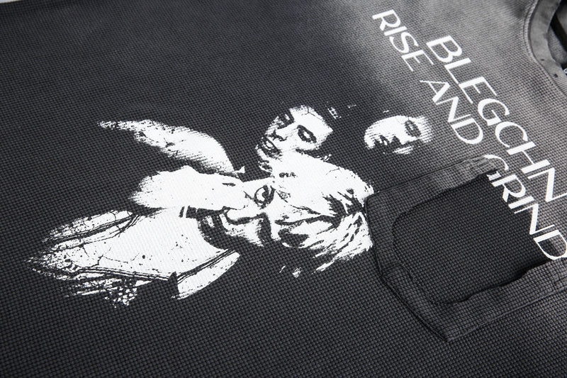 Close-up of front graphic and chest pocket on black waffle knit long sleeve tee