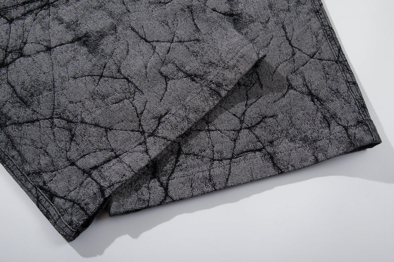 Close-up of hem on gray cracked-texture wide-leg denim pants