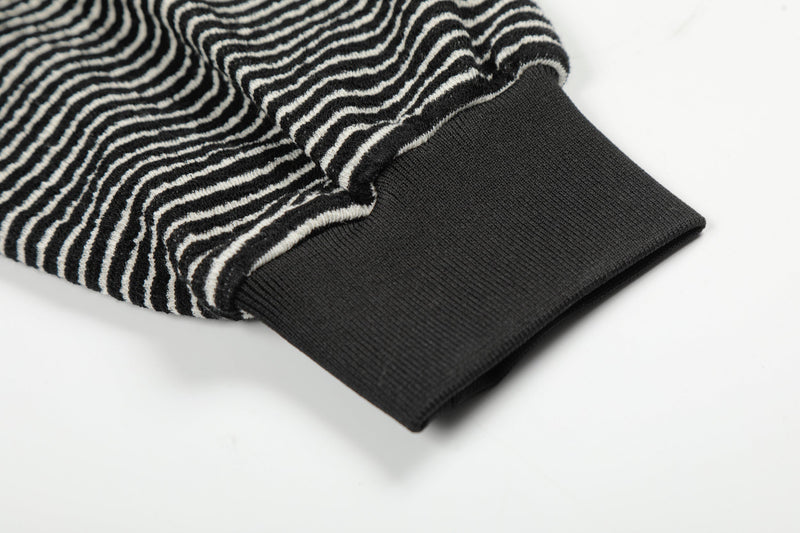 Close-up of black ribbed sleeve cuff on striped hoodie