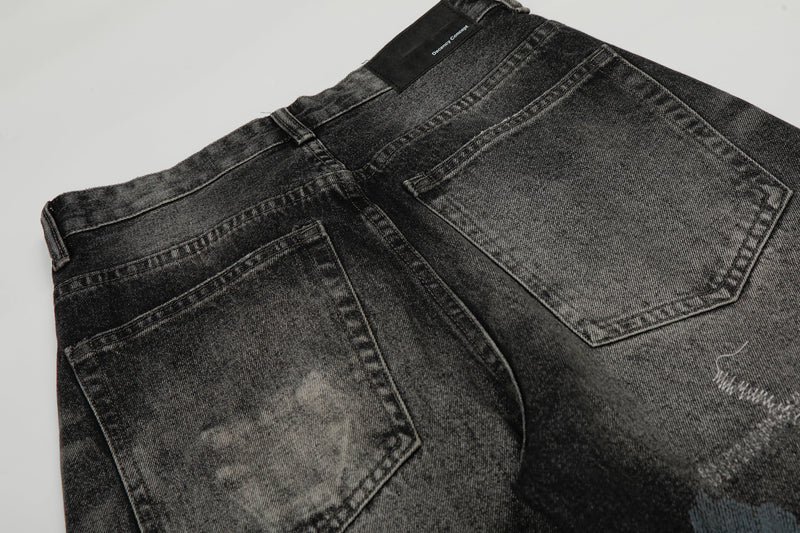 Back waist close-up of black washed denim pants showing rear pockets and brand patch