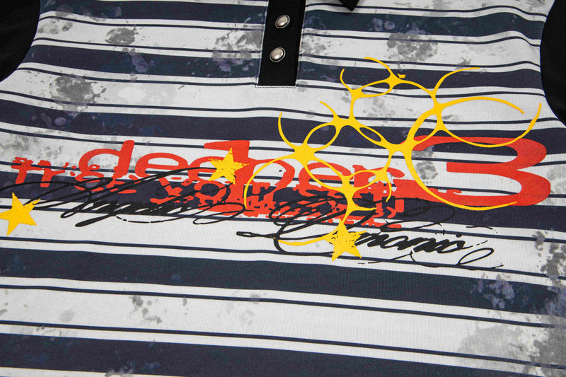 Close-up of a vintage striped polo tee with bold red and yellow graphic print and black snap placket