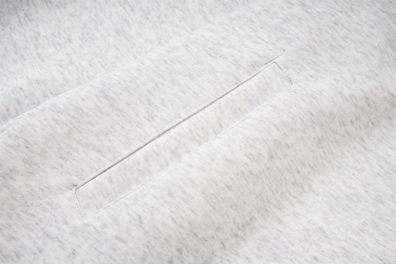 Close-up of a hoodie welt pocket on light gray heather fabric