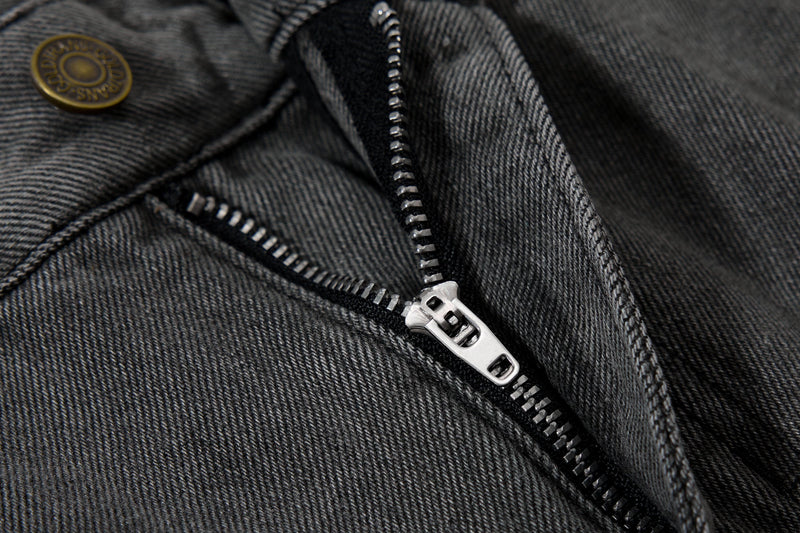 Close-up of zipper fly and front button on black washed denim jeans