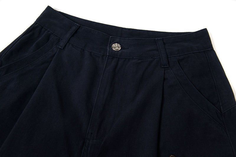 Black pants waistband with metal button and belt loops, close-up
