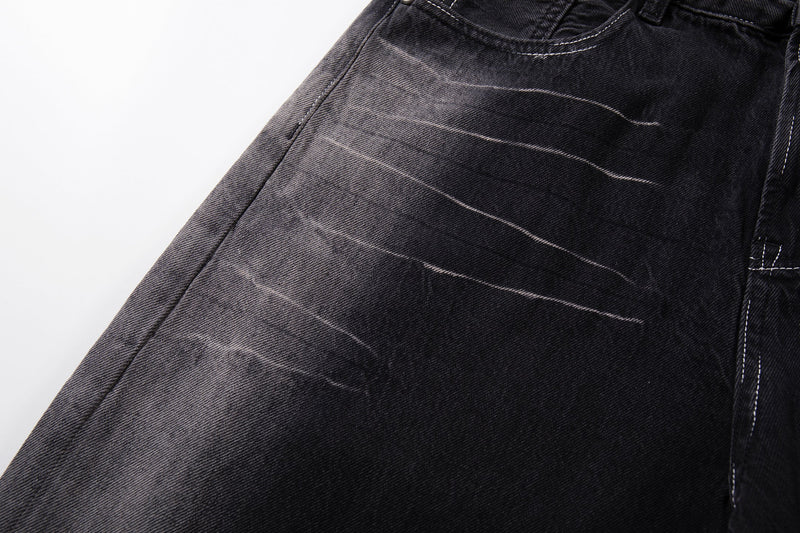 Close-up of faded diagonal whiskering on dark wash denim pant leg