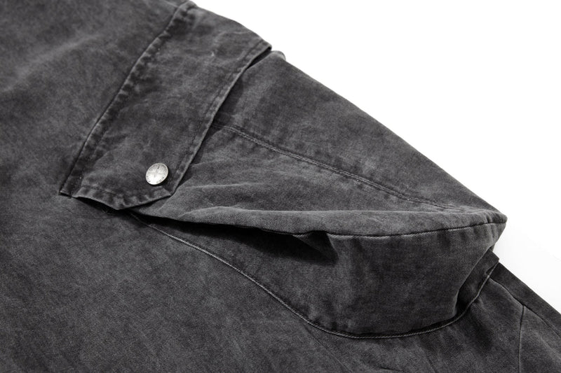 Close-up of side cargo flap pocket with snap button on washed black pants