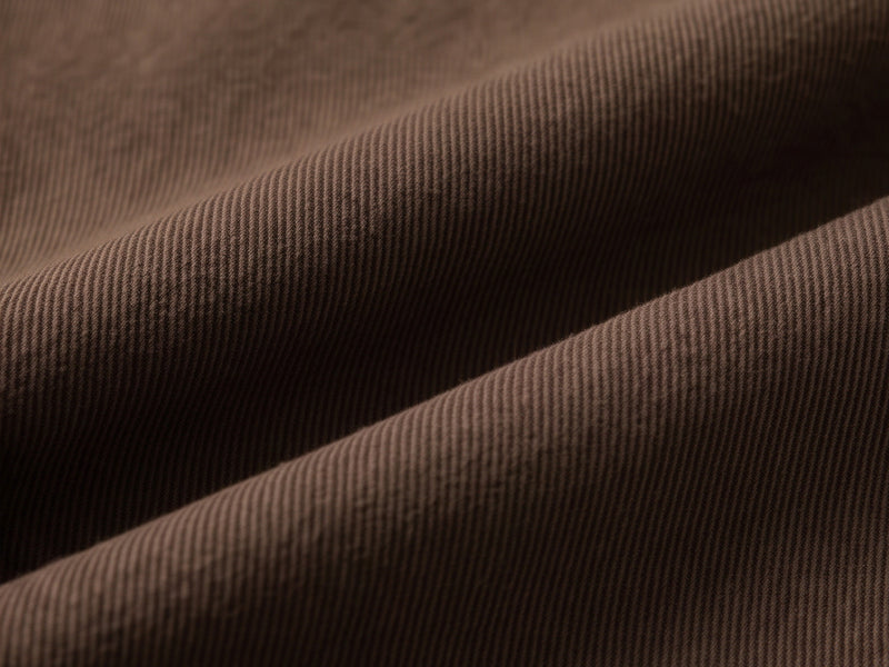 Close-up of brown cotton fabric with diagonal ribbed texture