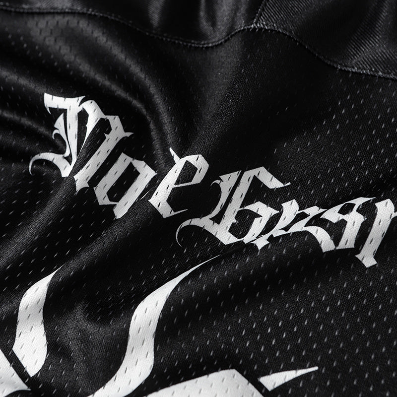 Close-up of black mesh football jersey with bold white gothic graphic lettering and streetwear style print