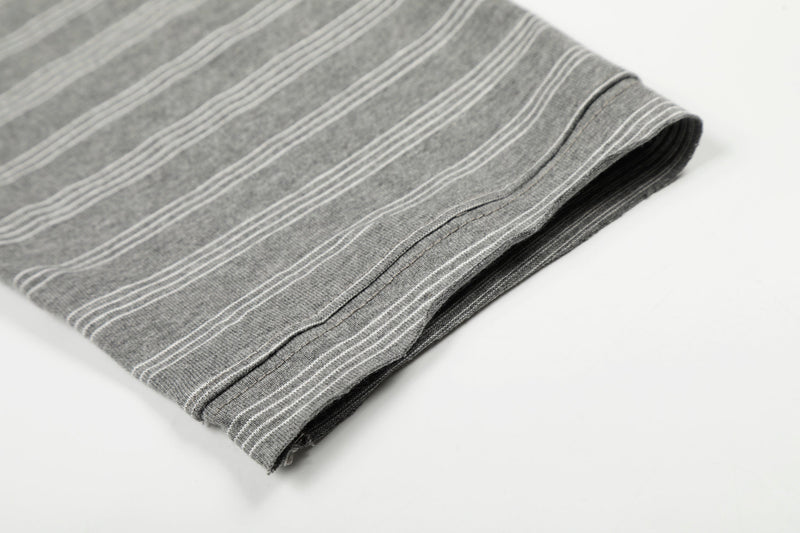 Folded gray striped long sleeve tee showing sleeve cuff and hem stitching