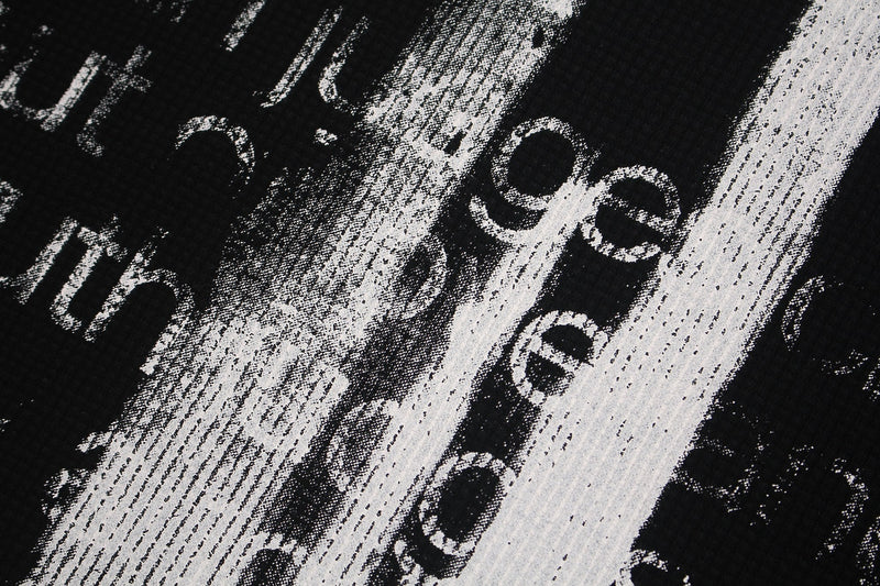 Close-up of black tee graphic with distressed white gothic cross and bold streetwear lettering