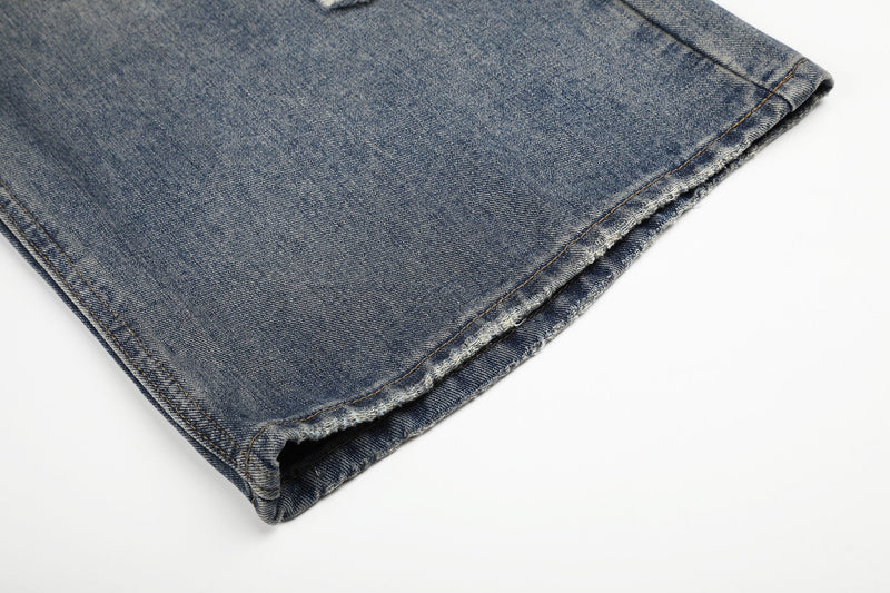 Close-up of frayed hem on faded blue denim wide-leg jeans