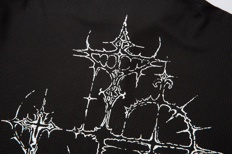 Close-up of black shirt front with white thorny graphic and partial lettering