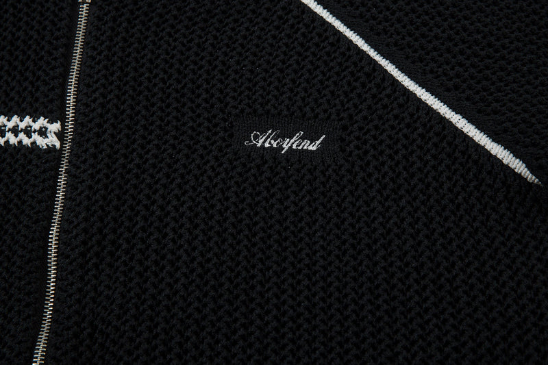 Black chest logo and shoulder stripe detail on mesh knit jacket close-up