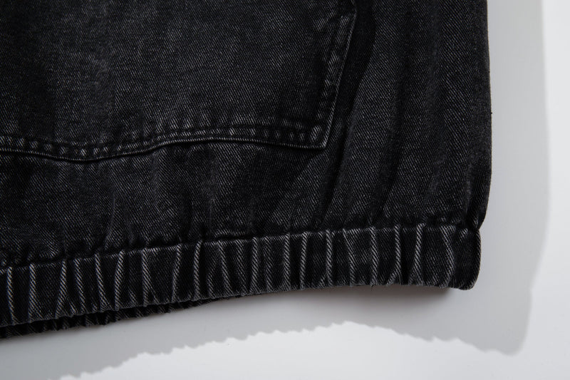 Close-up of black denim hem with ribbed elastic trim