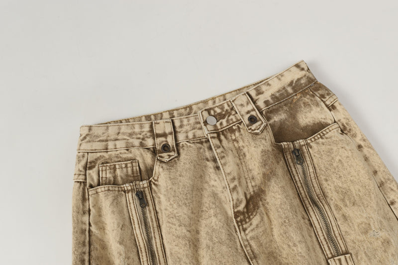 Front upper view of beige wide-leg jeans with zipper pockets and button waistband