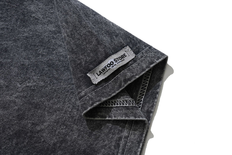 Vintage wash black graphic tee sleeve detail with sewn hem and Lavawood Store label on a textured cotton fabric