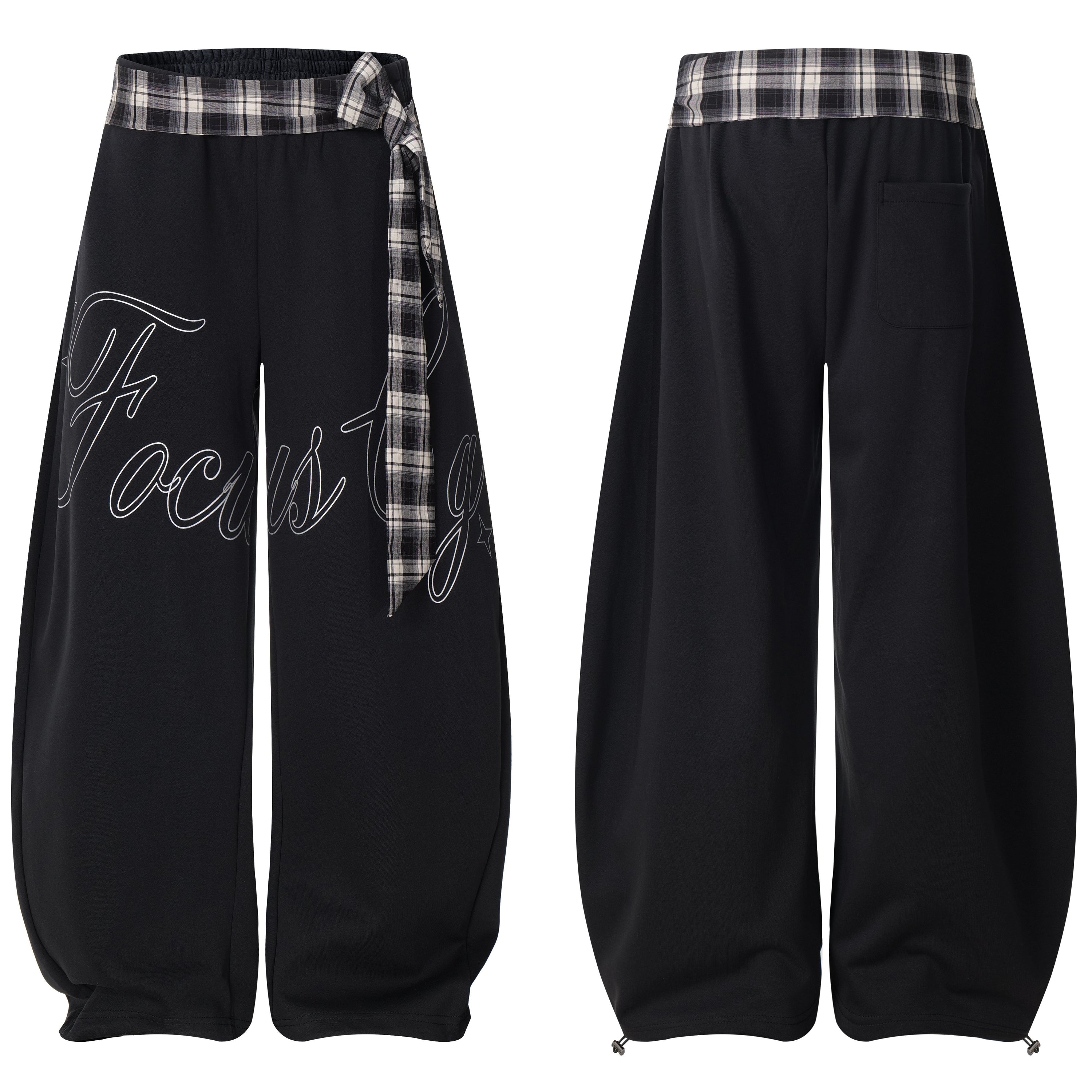 Black barrel-fit track pants with plaid waistband tie and cursive Focus script print, shown front and back