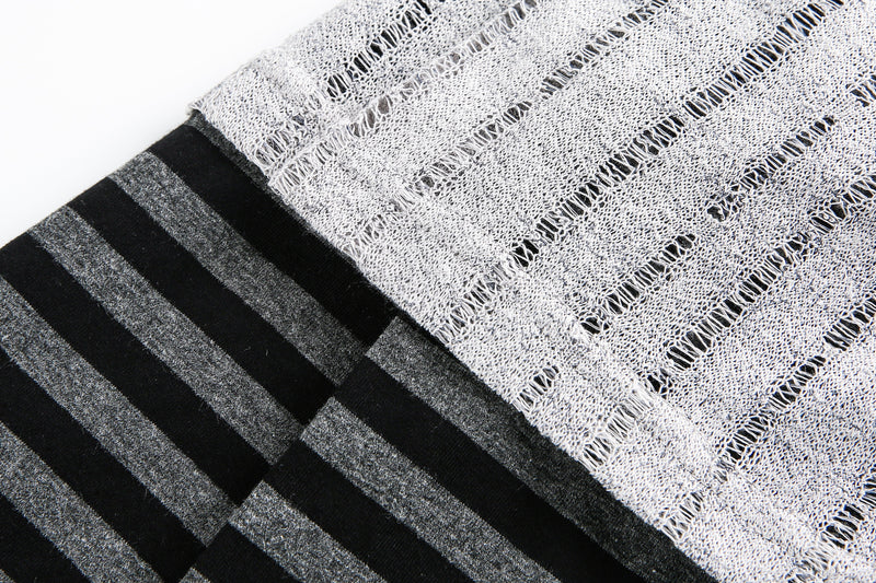 Close-up of striped sleeve seam beside the gray knit body