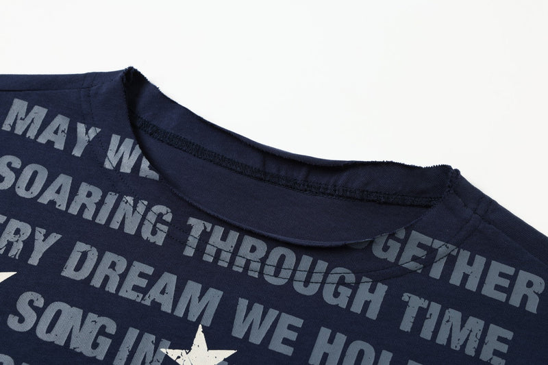 Close-up of navy tee neckline with distressed gray printed text and white star graphics