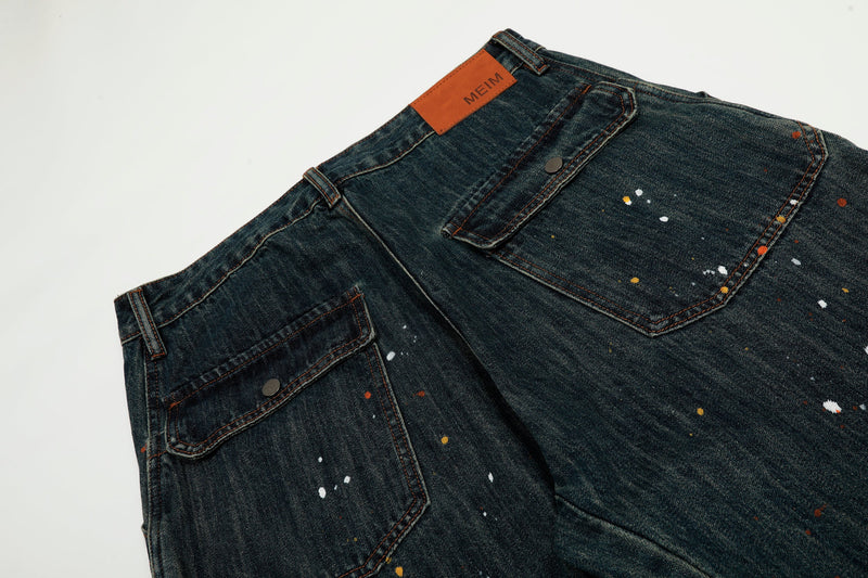 Back pocket and leather logo patch on dark wash paint-splatter jeans