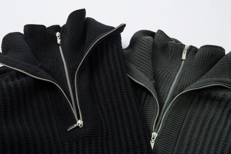 Close-up of two ribbed knit sweaters showing open half-zip collars and silver zippers