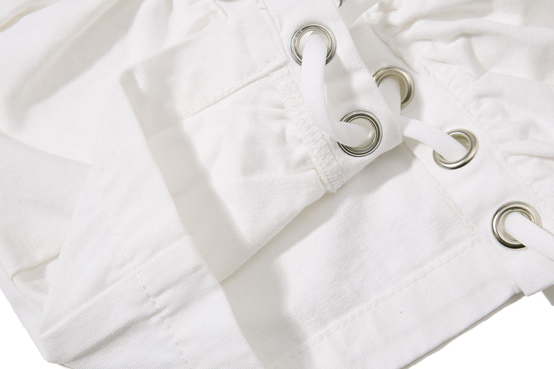 White shorts lace-up panel with metal eyelets, close-up