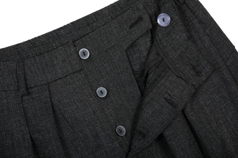 Close-up of the buttoned front waistband on black pleated wide-leg pants