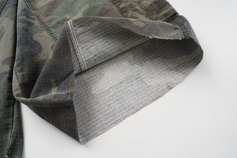 Close-up of the open leg hem showing the light inner lining on camouflage cargo shorts