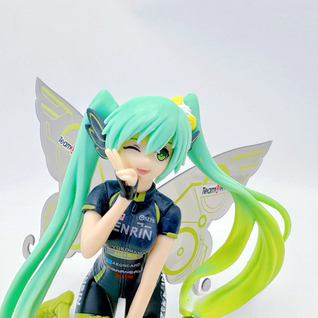 The Racing Butterfly Hatsune Miku 12cm PVC Figure from Team MIKYO captures her in a playful pose with long green hair, dark cycling outfit, and delicate butterfly wings against a plain white backdrop—a captivating tribute for any Vocaloid fan.