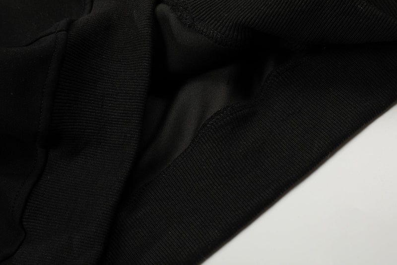 Close-up of black hoodie fabric and ribbed sleeve seam