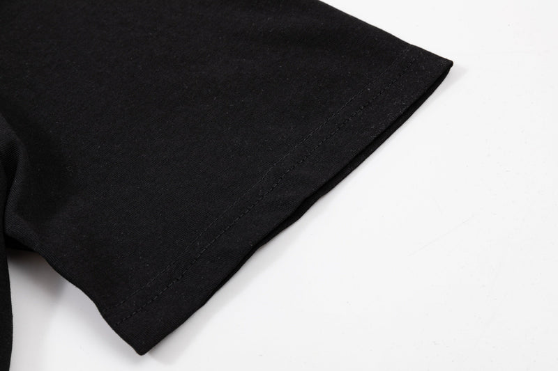 Black oversized graphic tee sleeve with clean hem stitching on a white background