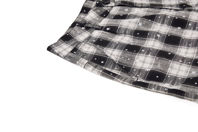 Lower leg hem of black and white plaid cargo shorts with star print