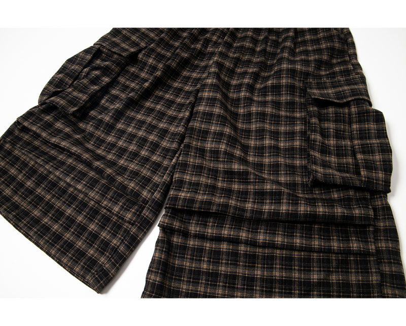 Flat lay of plaid cargo shorts showing wide legs and side cargo pockets