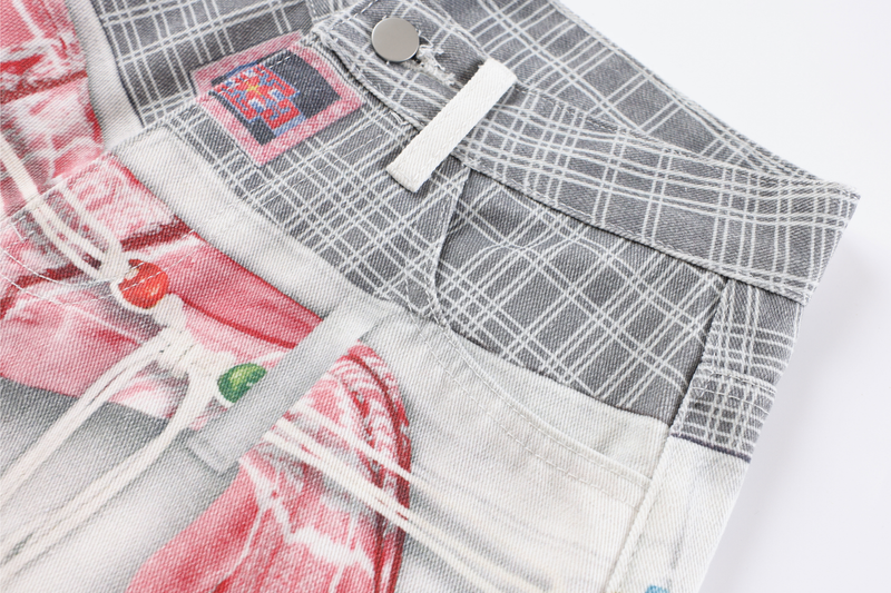 Angled close-up of gray plaid waistband and front patchwork denim with button and drawstring