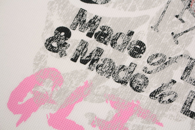 Close-up of white streetwear tee with distressed black Made of Love graphic and pink heart print