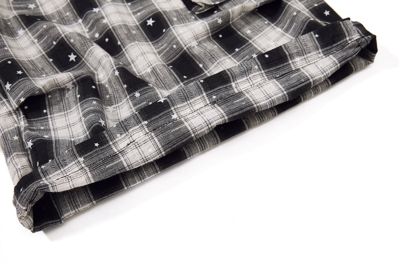 Folded hem detail on black and white plaid shorts with star print