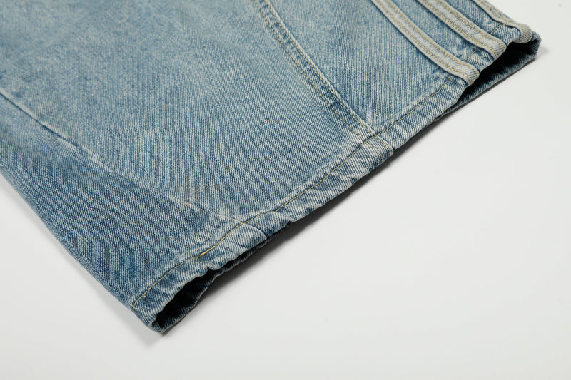 Folded hem of light wash denim with visible stitched side seam