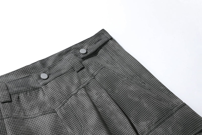 Close-up of black mesh shorts waistband corner with snap button and seam stitching